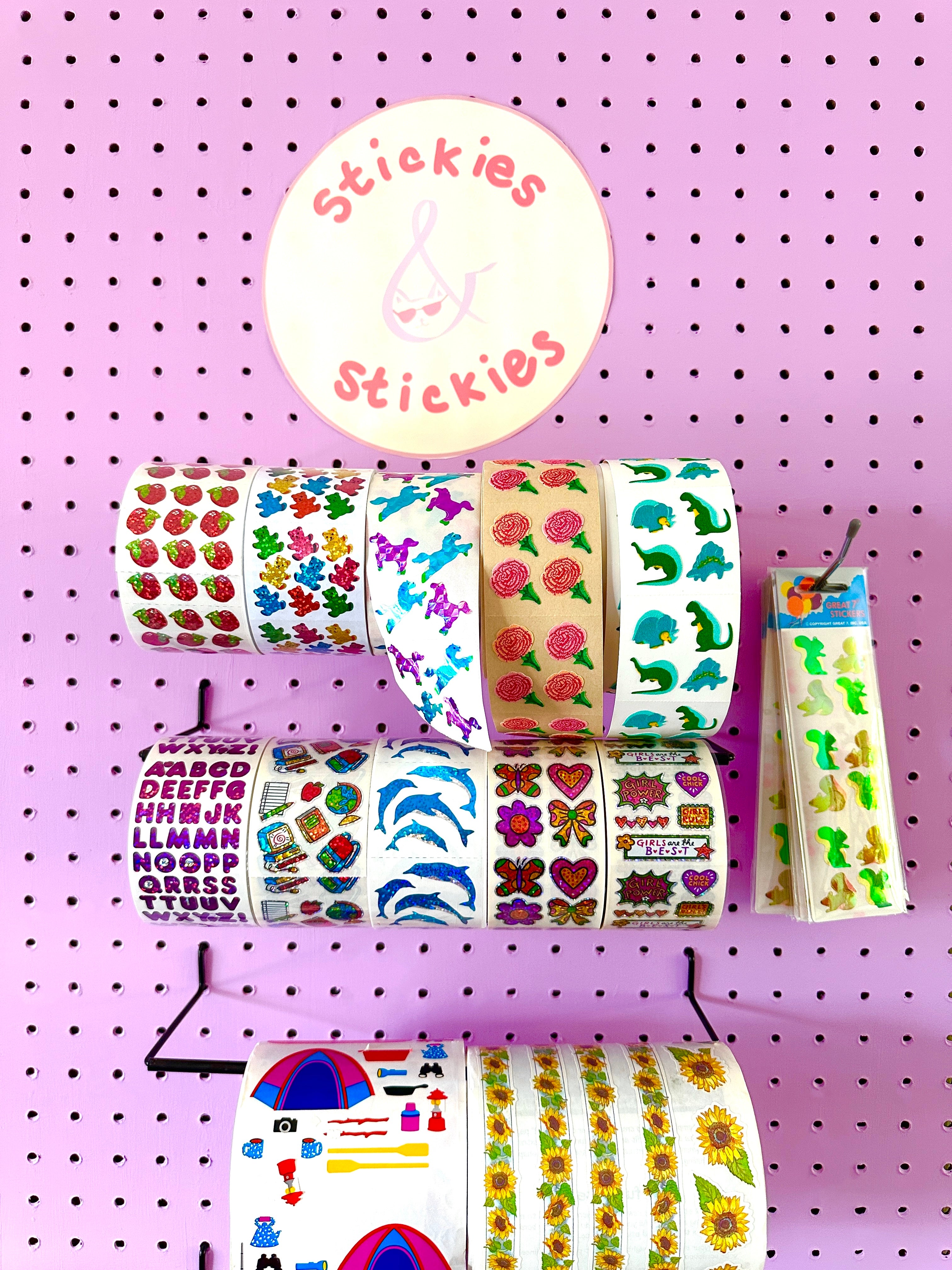 Rolls of stickers on a pegboard with 'Stickies' branding.